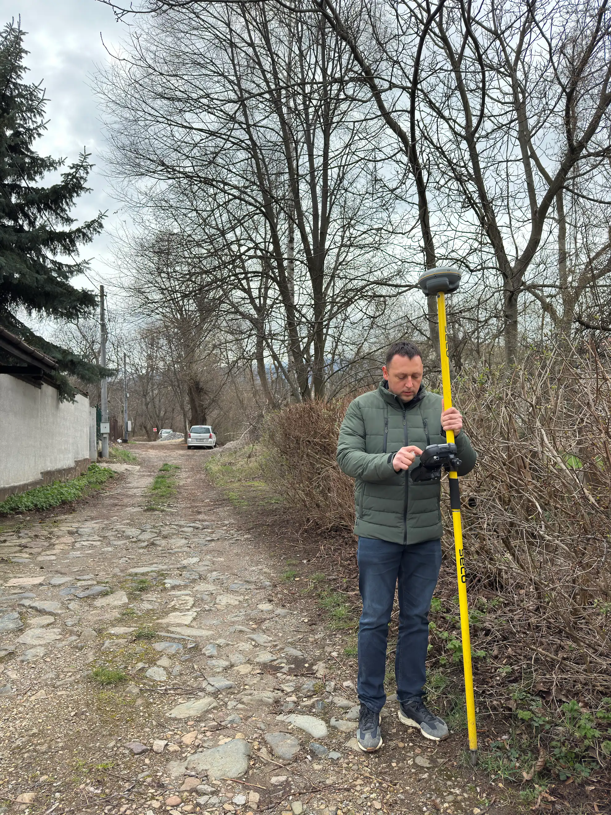 Геодезист с GNSS приемник при заснемане на терен